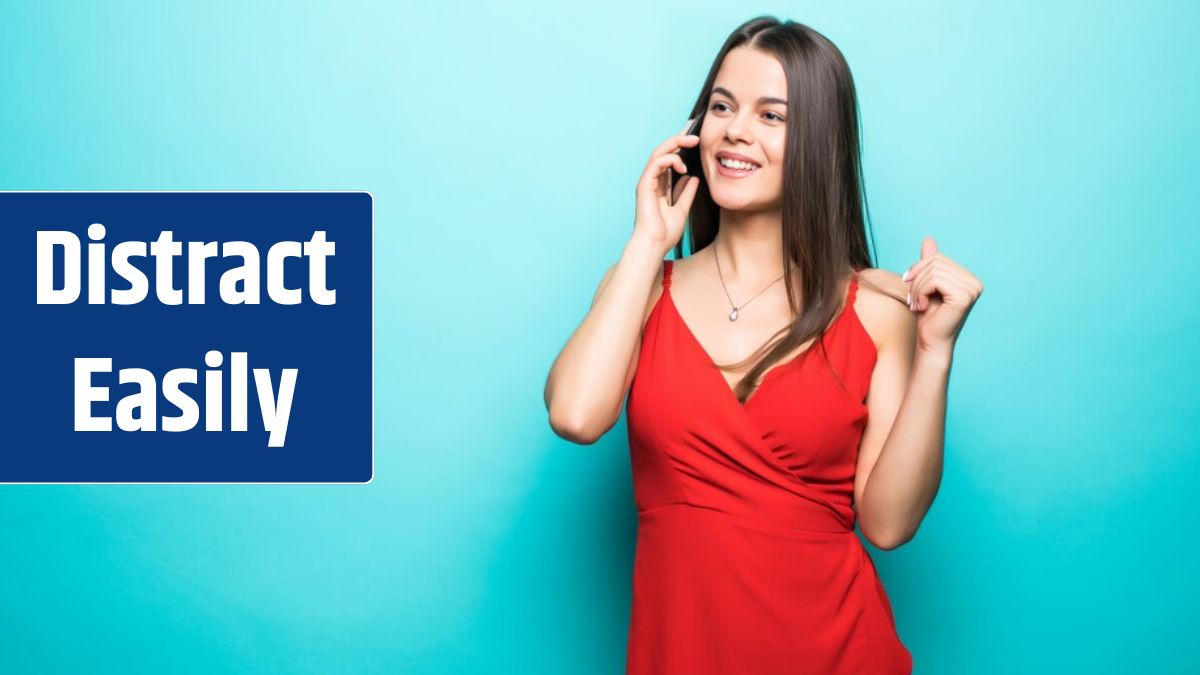 Portrait of a cute happy girl in dress talking on mobile phone and laughing isolated over blue wall.