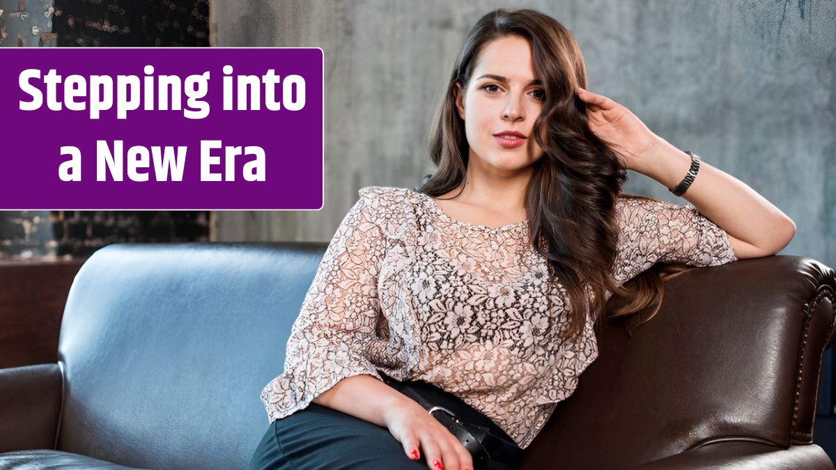 An attractive young woman sitting on sofa looking at camera.