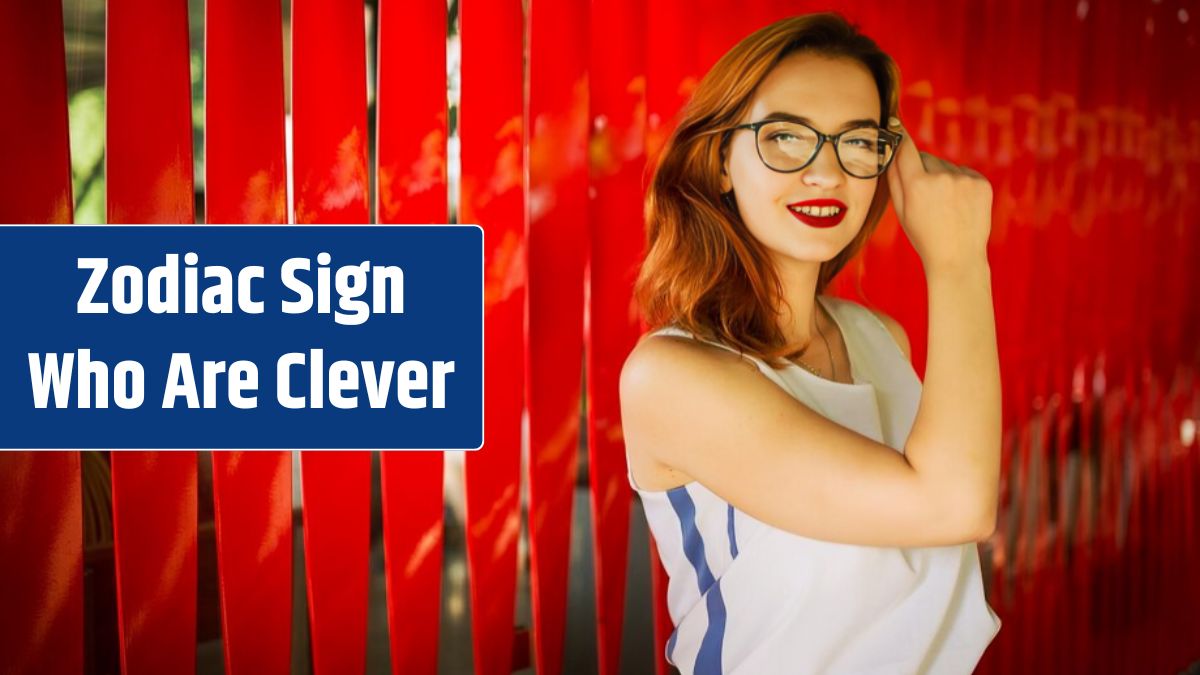 Attractive redhaired woman in eyeglasses posing against red background.