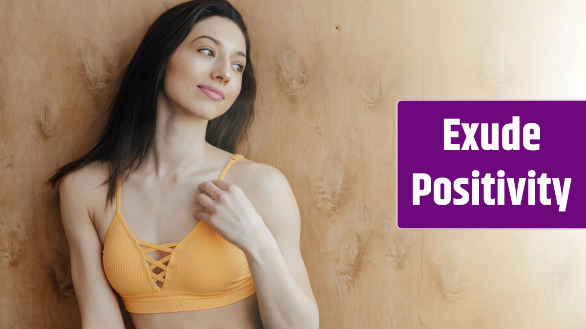 Young attractive fitness girl sitting on the floor near the window on the wall of a wooden wall, resting on yoga classes.