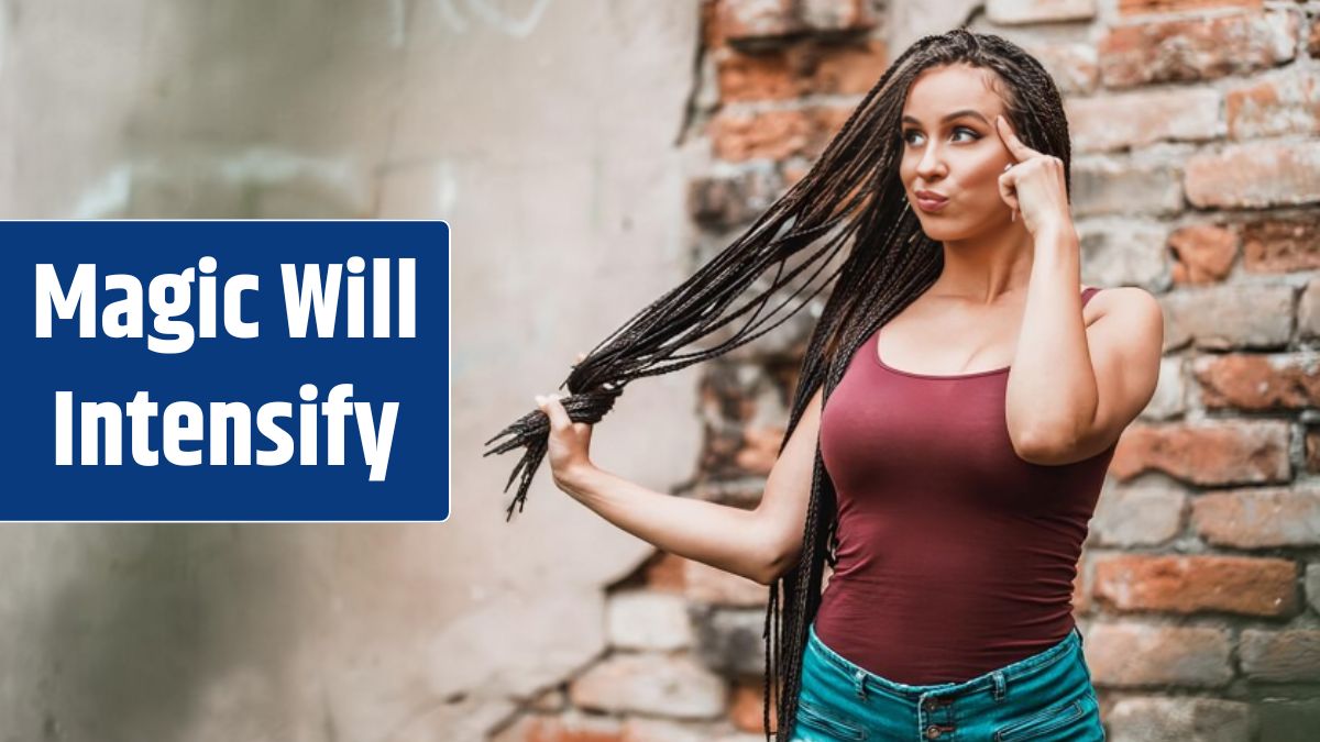 Cute young woman with long afro braided hair pouting her lips and having fun against a brick wall.